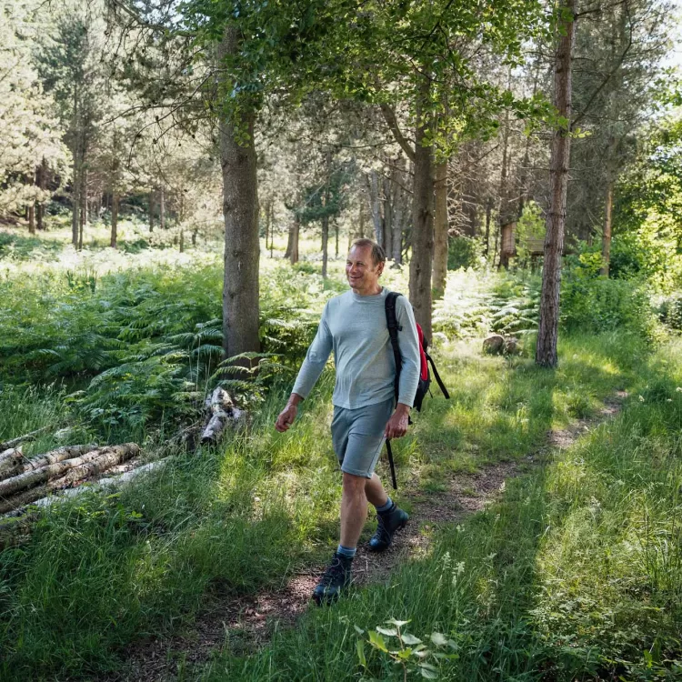 Man walking in woods reconnecting with nature